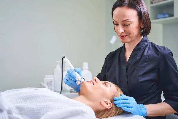 Mujer joven y amable que trabaja en el salón de belleza — Foto de Stock