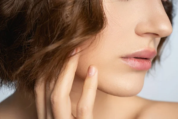 Fotografía enfocada en la mano femenina que toca la cara — Foto de Stock