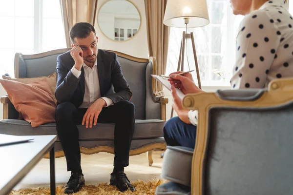 Trauriger Kaukasier starrt seinen Psychotherapeuten an — Stockfoto