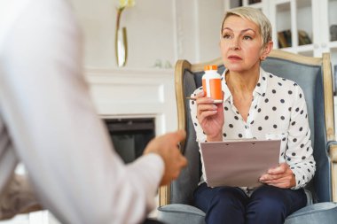 Doktor plastik şişede ilaç gösteriyor.