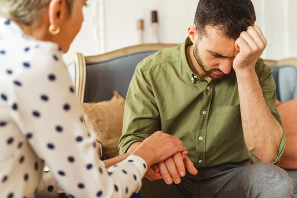 Psicólogo sosteniendo una mano de pacientes masculinos alterados — Foto de Stock