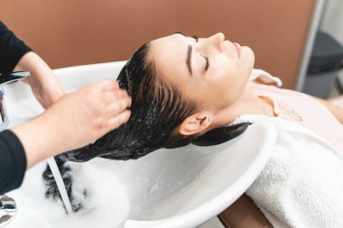 Uzun saçlı bir esmer, en sevdiği salonu ziyaret ediyor.