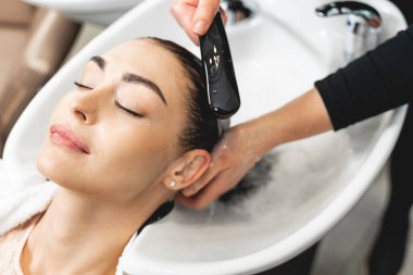 Çekici esmer kız güzellik salonundaki güzellik prosedürlerinden hoşlanıyor.