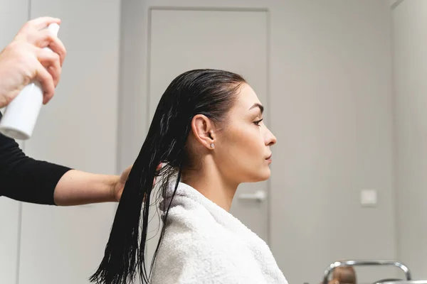 Joven morena de pelo largo mirando su reflejo — Foto de Stock