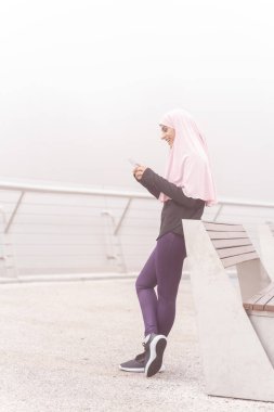 Yeni mesajlar okuyor ve gülümsüyor.