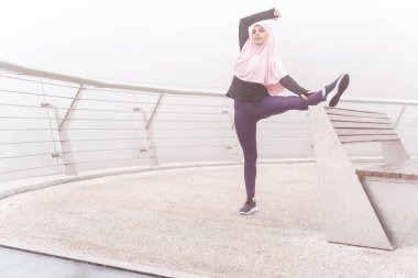 Sporcu kadın yedek kulübesinde egzersiz yapıyor.