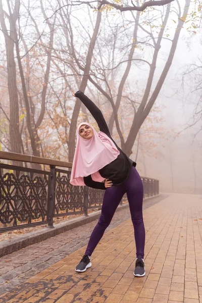 Musulmane sportive exercer dans le parc et faire des virages photo de stock — Photo