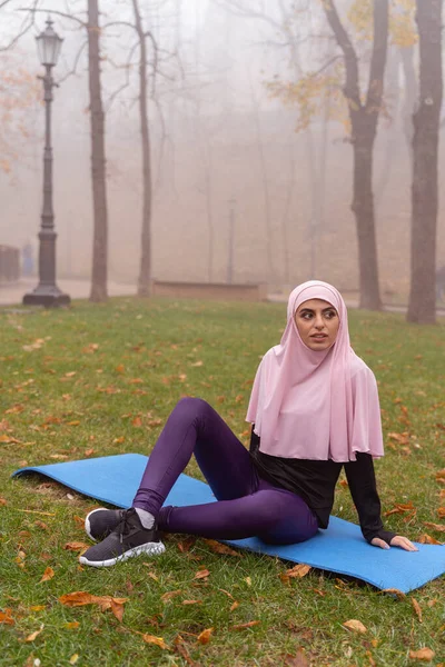 Belle femme assise sur le tapis de yoga photo de stock — Photo