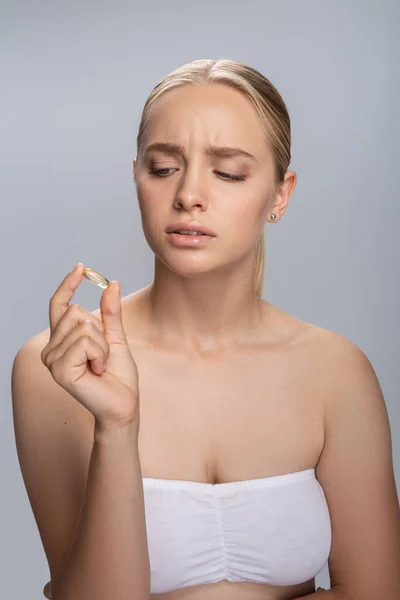 Uppmärksam blond kvinna stirrar på gelé tablett — Stockfoto