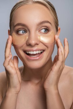 Makyajdan önce sabah ameliyatı yapan neşeli genç bir sarışın.