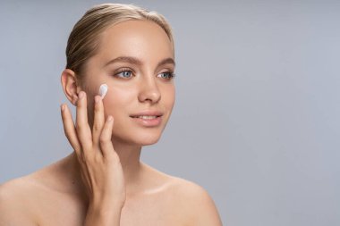 Krem test eden mutlu bir kızın portresi.