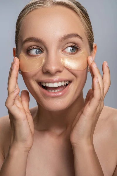 Joven rubia alegre haciendo el procedimiento de la mañana antes del maquillaje —  Fotos de Stock