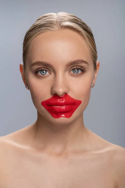 Крупный план симпатичной девушки, которая делает маску для губ — стоковое фото