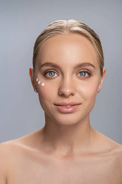 Retrato de menina bonita que usando creme — Fotografia de Stock