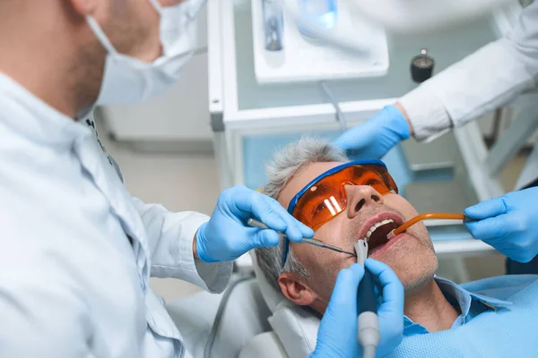 Homem tratando dentes na clínica fotos stock — Fotografia de Stock