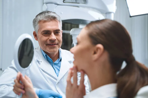 Le dentiste profite du résultat avec la photo du patient — Photo