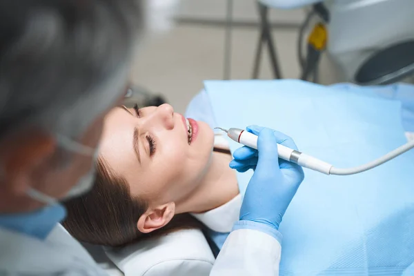 Dentista está tratando joven mujer stock foto — Foto de Stock