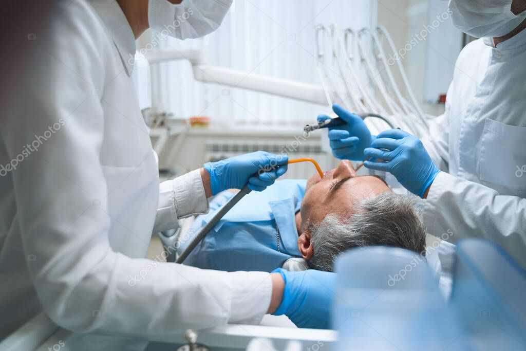 Two dentists are treating male stock photo