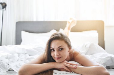 Gülümseyen genç kadın kameraya poz veriyor.