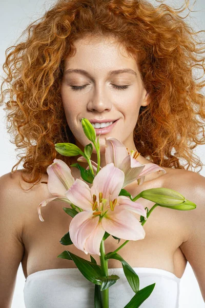 Glückliche schöne rote Dame mit rosa Lilien — Stockfoto