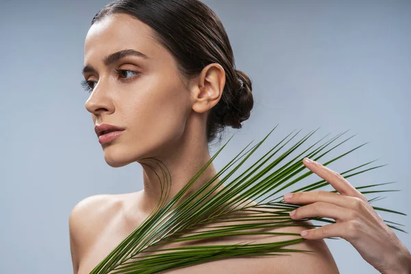 Lugn ung naken kvinna med palmblad — Stockfoto