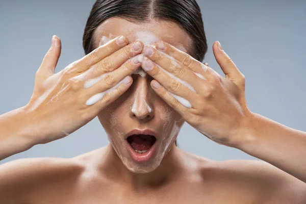 Jovem mulher lavando o rosto com sabão — Fotografia de Stock