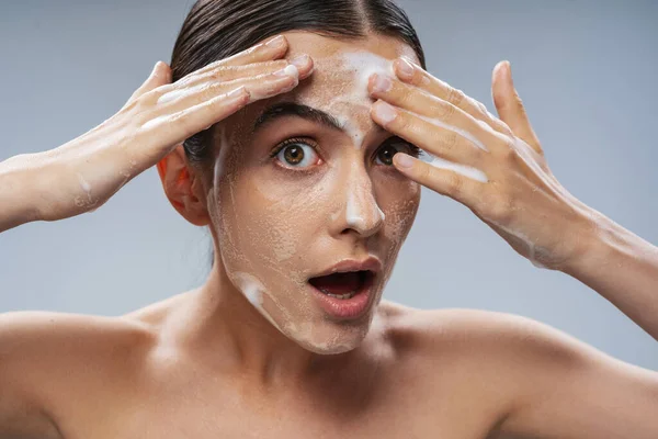 Schöne junge Dame wäscht Gesicht mit Seife — Stockfoto