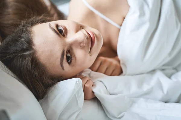 Mujer bonita sonriente relajándose en su dormitorio — Foto de Stock