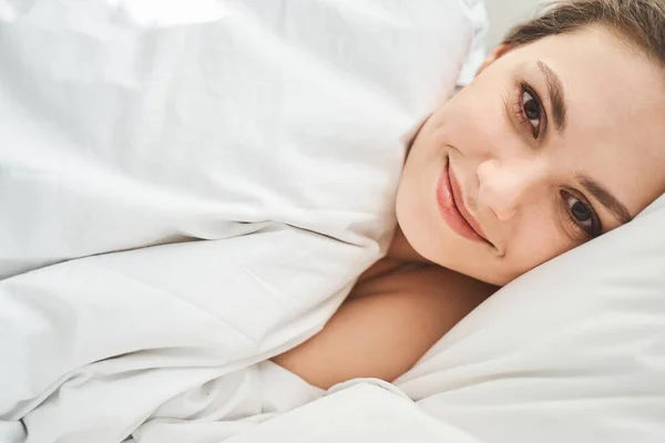 Sonriente chica rubia acostada en una almohada —  Fotos de Stock