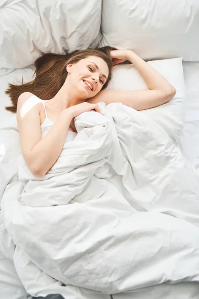 Девочка с длинными волосами лежит в постели — стоковое фото