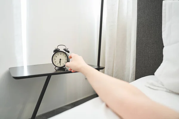 Dedos de mujer tocando un reloj en un dormitorio — Foto de Stock