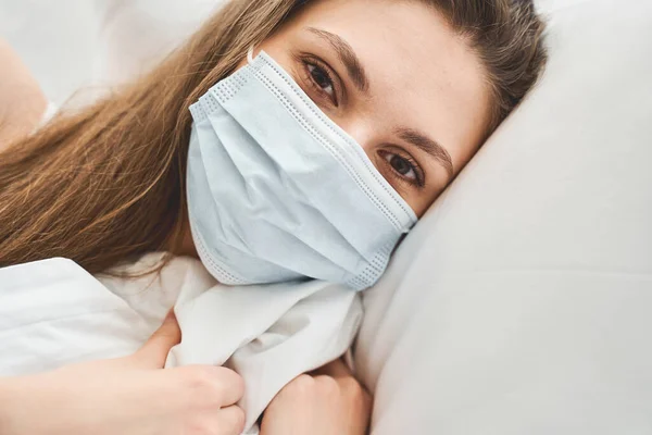 Meisje met een masker dat voor haar kijkt — Stockfoto