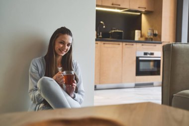 Gülümseyen, uzun saçlı, güzel bir kadın ileriye bakıyor.