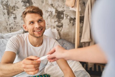 Hamilelik testine giren mutlu genç bir adam.
