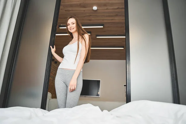 Pen ung dame som står i døråpningen – stockfoto