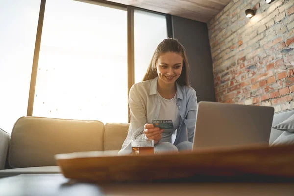 Lycklig kvinna sitter framför sin bärbara dator — Stockfoto