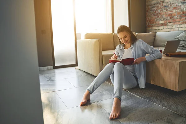 Femmina fissando un diario in ginocchio — Foto Stock