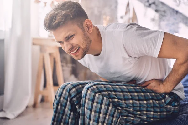 Emotional brunette male person touching his stomach — Stock Photo, Image