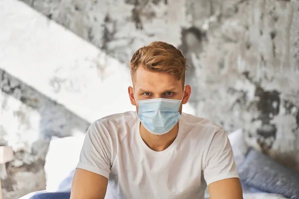 Junger brünetter Mann trägt sterile medizinische Maske — Stockfoto