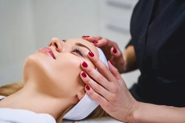 Mulher bonita desfrutando de massagem facial foto stock — Fotografia de Stock