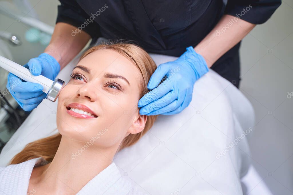 Smiling jolly female at cosmetologist stock photo