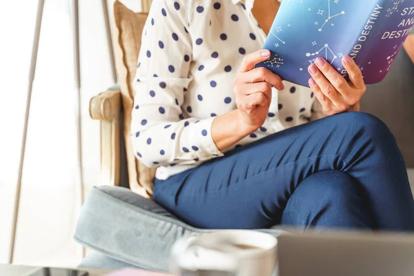 Frau in gepunkteter Bluse sitzt auf einer Couch — Stockfoto