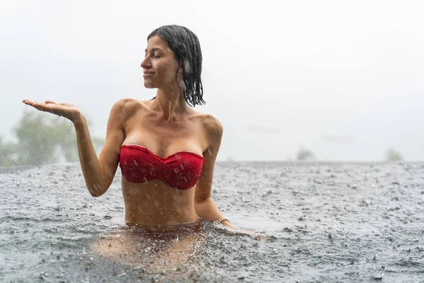 Meisje in een rode beha zittend in het water — Stockfoto