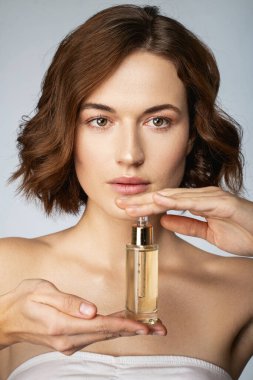 Ellerinde serum olan sakin genç bir kadın.