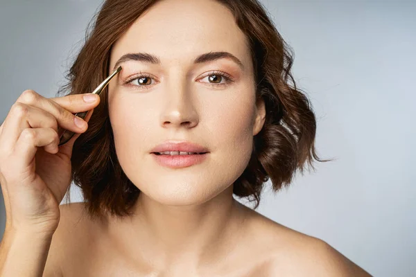 Alegre hermosa joven haciendo el estilo de las cejas — Foto de Stock