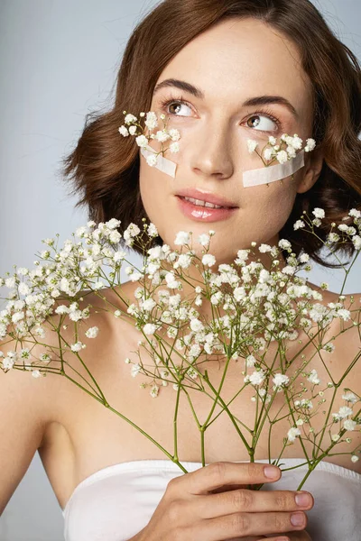 Mujer joven feliz con ramo de flores blancas pequeñas y frescas —  Fotos de Stock