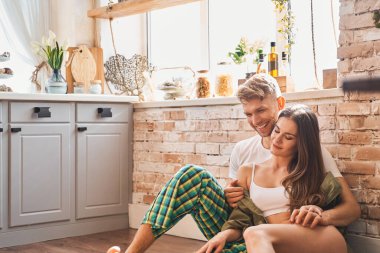 Neşeli esmer adam şefkatli kızını kucaklıyor.