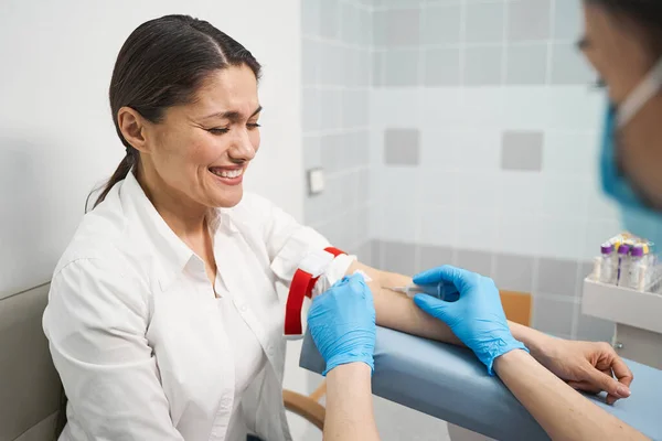 Giovane donna emotiva che dà campione del suo sangue — Foto Stock