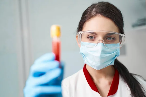 Joven practicante concentrado mirando directamente al tubo de ensayo — Foto de Stock