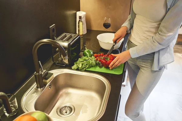Женщина режет овощи на пластиковой доске — стоковое фото